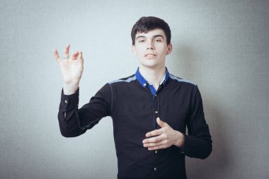 Gri arka planda poz veren genç adam