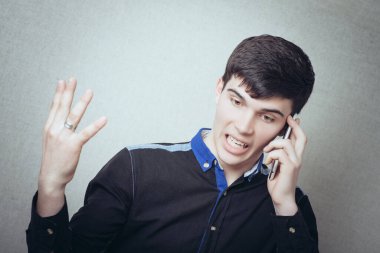 Telefondaki adam bağırıyor. Sevimsiz davranışlar, telefonda konuşmalar. Gri bir arkaplanda
