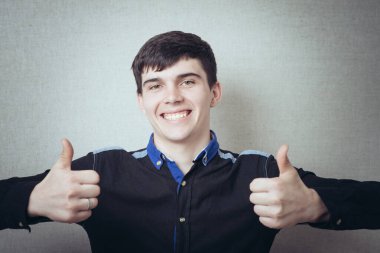 Genç adam başparmağını kaldırıyor.