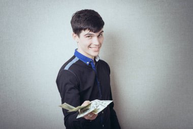 Amerikan kağıt para birimini elinde tutan gülümseyen genç adamın portresi 