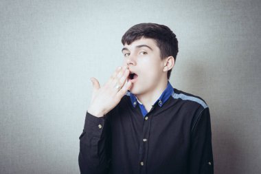 Genç adam esnedi ve ağzını eliyle kapattı.