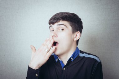 Genç adam esnedi ve ağzını eliyle kapattı.