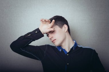 Baş ağrısı çeken genç bir adam.
