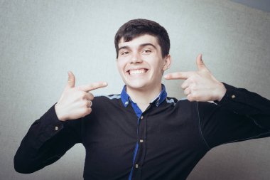 Sağlıklı gülüşüne ya da dişlerine bakan yakışıklı bir adamın portresi.