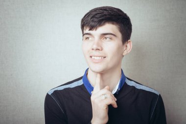 Genç iş adamı yakın çekim. Çenesine dokunuyor.