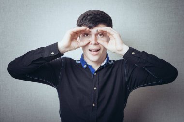 Konsantre iş adamı elleriyle dürbün yapıyor ve bakıyor. 