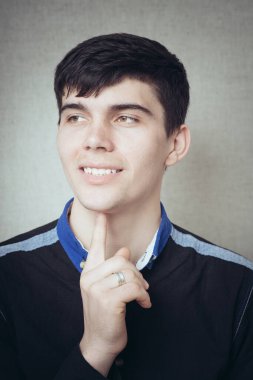 Genç iş adamı yakın çekim. Çenesine dokunuyor.