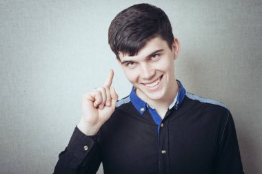 Genç adam işaret ediyor, bir şey gösteriyor, bir fikri var.