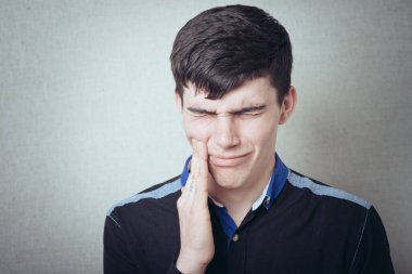 Dişi ağrıyan genç bir adam.