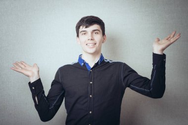 Eller farklı yönlerde, hareket, boş, hiçbir şey, hiçbir şey bilmiyorum, ve işte buradayım, gri arka planda genç yakışıklı bir adam