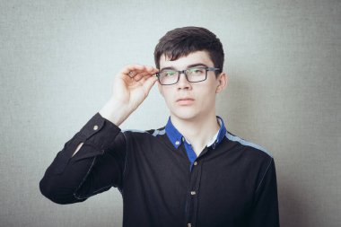 Gözlüklü ciddi bir adam. Gri bir arkaplanda.