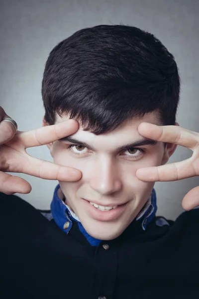 Young Man Makes Gesture Victory Gray Background — Stock Photo, Image