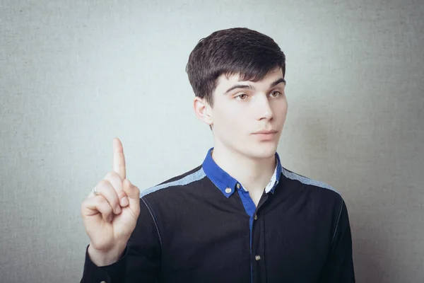 Молодий Чоловік Вказує Пальцем Ідею Сірому Тлі — стокове фото
