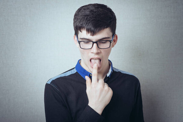 молодой человек, показывающий язык
