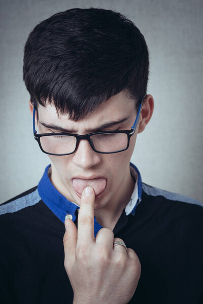 молодой человек, показывающий язык
