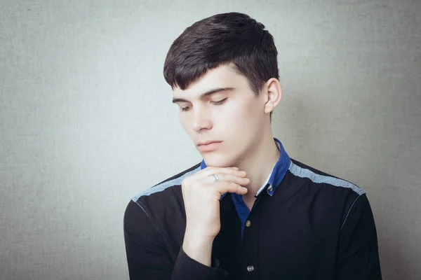 ハンサムな若い男のPentialと見て側に隔離された灰色の背景 — ストック写真