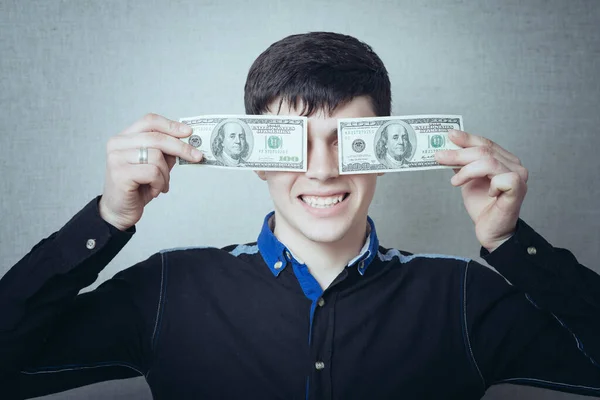灰色の背景にお金を保持している男の肖像画 — ストック写真