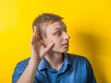 Etrafındaki sesleri duymaya çalışan genç bir adam.?