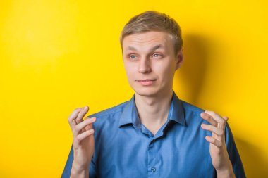 Yakışıklı genç adam şans dilemek için şans diledi. Kapalı portre. Jest yap. İzole edilmiş sarı arka plan. fotoğraf