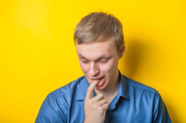 Diş ağrısı çeken genç adamlar sarı arka planda izole edilmiş.