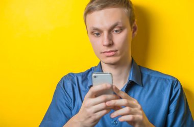 Genç yakışıklı adam cep telefonuna SMS yazıyor..