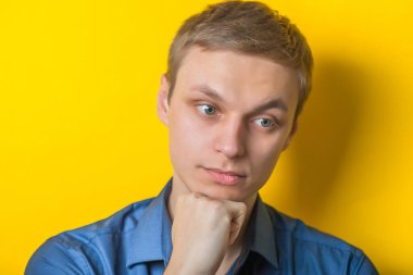 Sarı arka planda izole edilmiş yakışıklı, düşünceli bir adamın portresi.