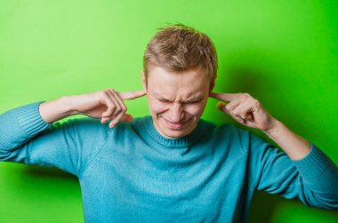 Parmağını şakağına dayamış genç bir adam.