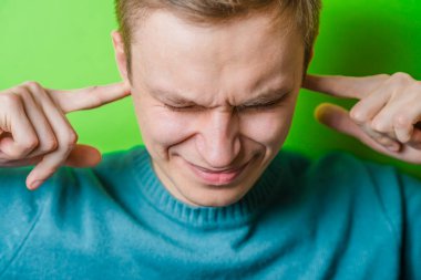 Parmağını şakağına dayamış genç bir adam.