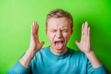 Öfkeli genç adamlar ellerini tutup çığlık atıyorlar.