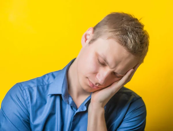 Молодой Человек Синей Рубашке Жёлтом Фоне Хотел Спать Закрытыми Глазами — стоковое фото