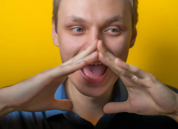 Eliyle Ağzını Kapatıyor Yüksek Sesle Bağırıyor Sarı Arka Plandaki Genç — Stok fotoğraf
