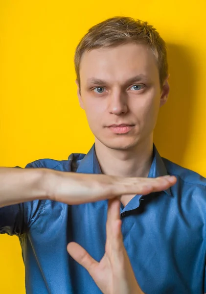 Jovem Empresário Uma Camisa Azul Fundo Amarelo Mostrando Hora Sinal — Fotografia de Stock