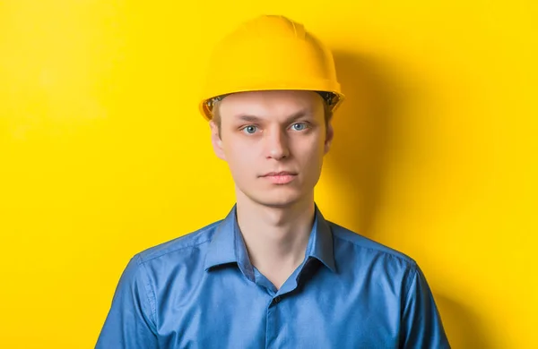Młody Mężczyzna Bliska Żółtym Hełmie Niebieska Koszula Żółtym Tle Patrzący — Zdjęcie stockowe