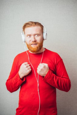 Kulaklıklı genç adam, gözleri kapalı hoş olmayan ya da akortsuz müziği dinliyor.
