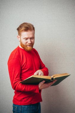 Genç, kızıl sakallı, kitaplı adam. 
