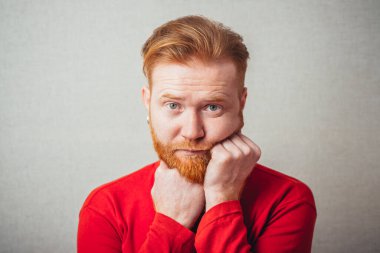 Sakallı, sıkılmış genç bir kızıl adam.