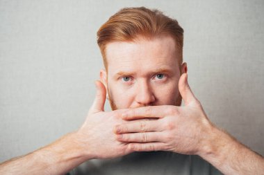 Sakallı adam elleriyle ağzını kapattı.