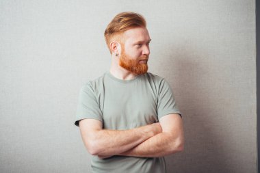 Sakallı adam ellerini katladı ve yana baktı.