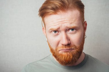 Genç kızıl sakallı adamın yüz ifadeleri.
