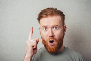 Genç bir erkeğin işaret parmağıyla fikri kavramı işaret ediyor. Retro vignette arka planında stüdyo portresi.