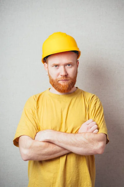 Homem Fundo Cinza Com Uma Barba Uma Camisa Amarela Capacete — Fotografia de Stock