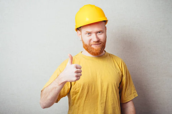 Homem Fundo Cinza Com Uma Barba Uma Camisa Amarela Capacete — Fotografia de Stock