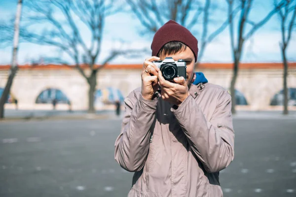Sokakta kameralı düşünceli bir erkek fotoğrafçı.