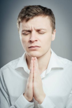 Genç işadamı dua ediyor. Beyaz arkaplan karşısında izole.