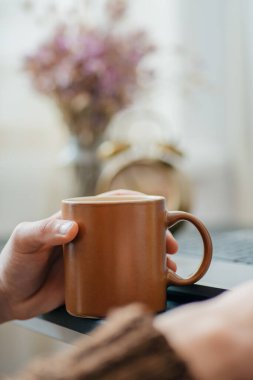 Erkek eli ve kahveye yakın çekim.