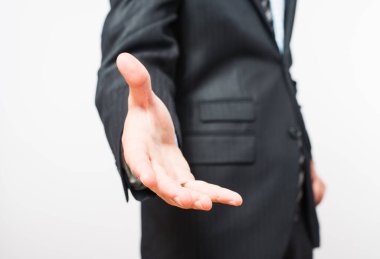 El sıkışmak için uzanan bir iş adamının yakın çekimi. Kırpma yolu da dahil olmak üzere beyazda izole edilmiş. İnce çizgili takım elbiseli bir iş adamı..