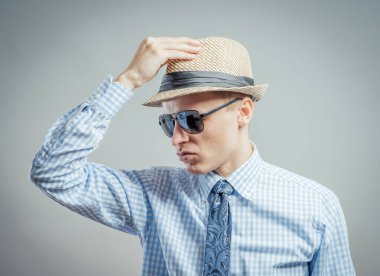 Şapkalı ve güneş gözlüklü genç bir adamın portresi..