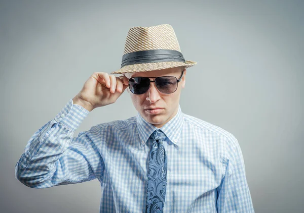 Şapkalı ve güneş gözlüklü genç bir adamın portresi..