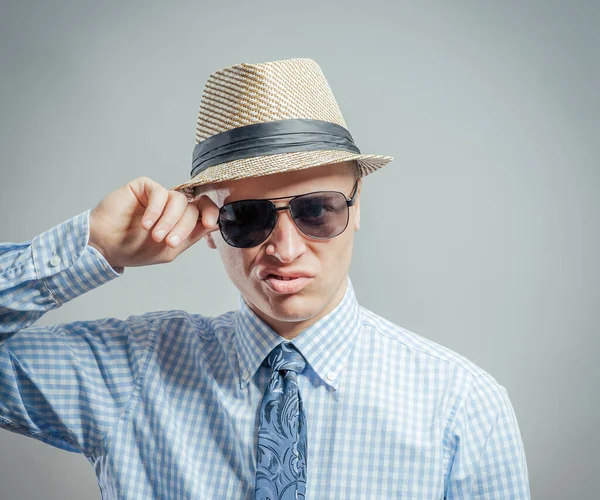 Şapkalı ve güneş gözlüklü genç bir adamın portresi..