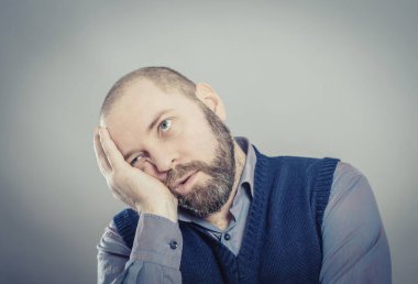 Gri arkaplanda sıkılmış bir adam